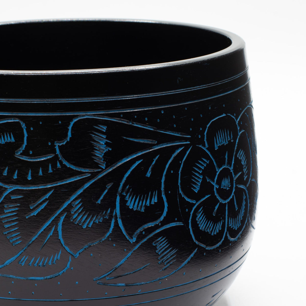 Close detail of the blue-engraved flower and leaves on the cauldron bowl
