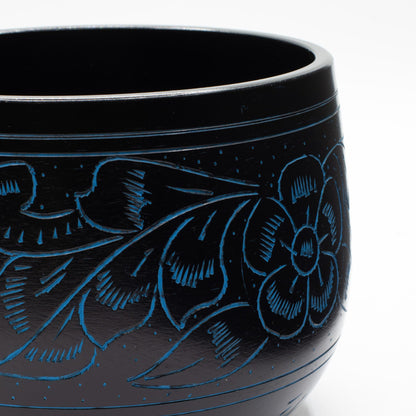 Close detail of the blue-engraved flower and leaves on the cauldron bowl