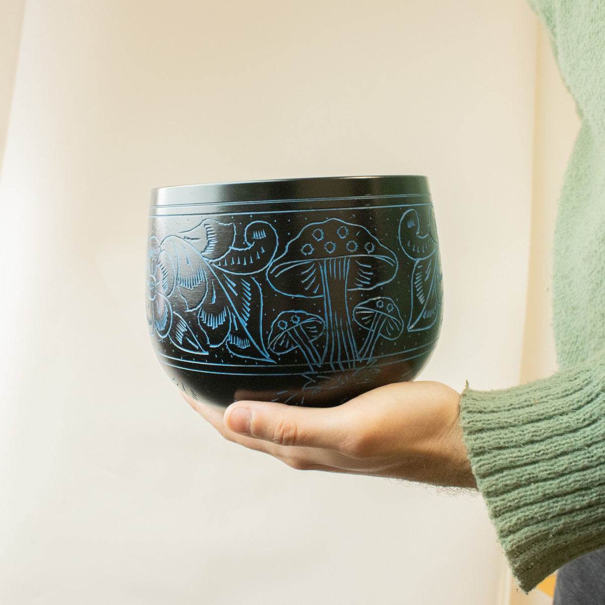Blue Magic Mushroom singing bowl held in an open hand to show its 15cm size