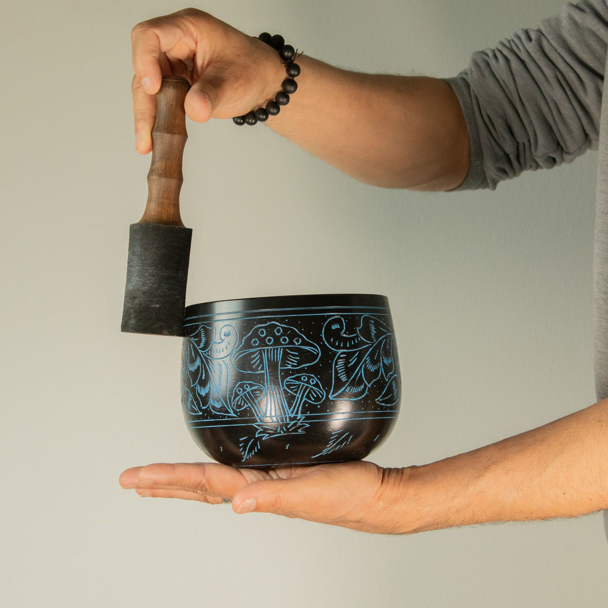 Blue Magic Mushroom bowl balanced on the palm and played with its wooden mallet