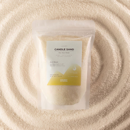 Blush Bloom fragranced candle sand in warm honey, 300g, in a resealable pouch on swirled sand
