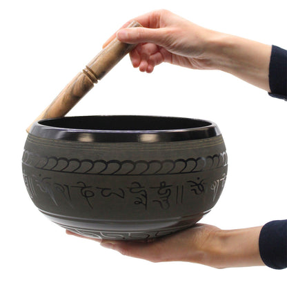 Five Buddha singing bowl held in the hand and played with a wooden mallet