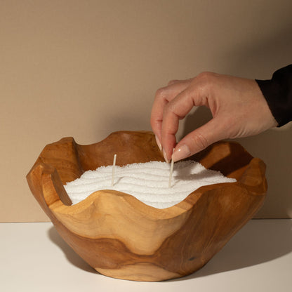 Unfragranced candle sand: placing a wick into the sand in a carved wooden bowl